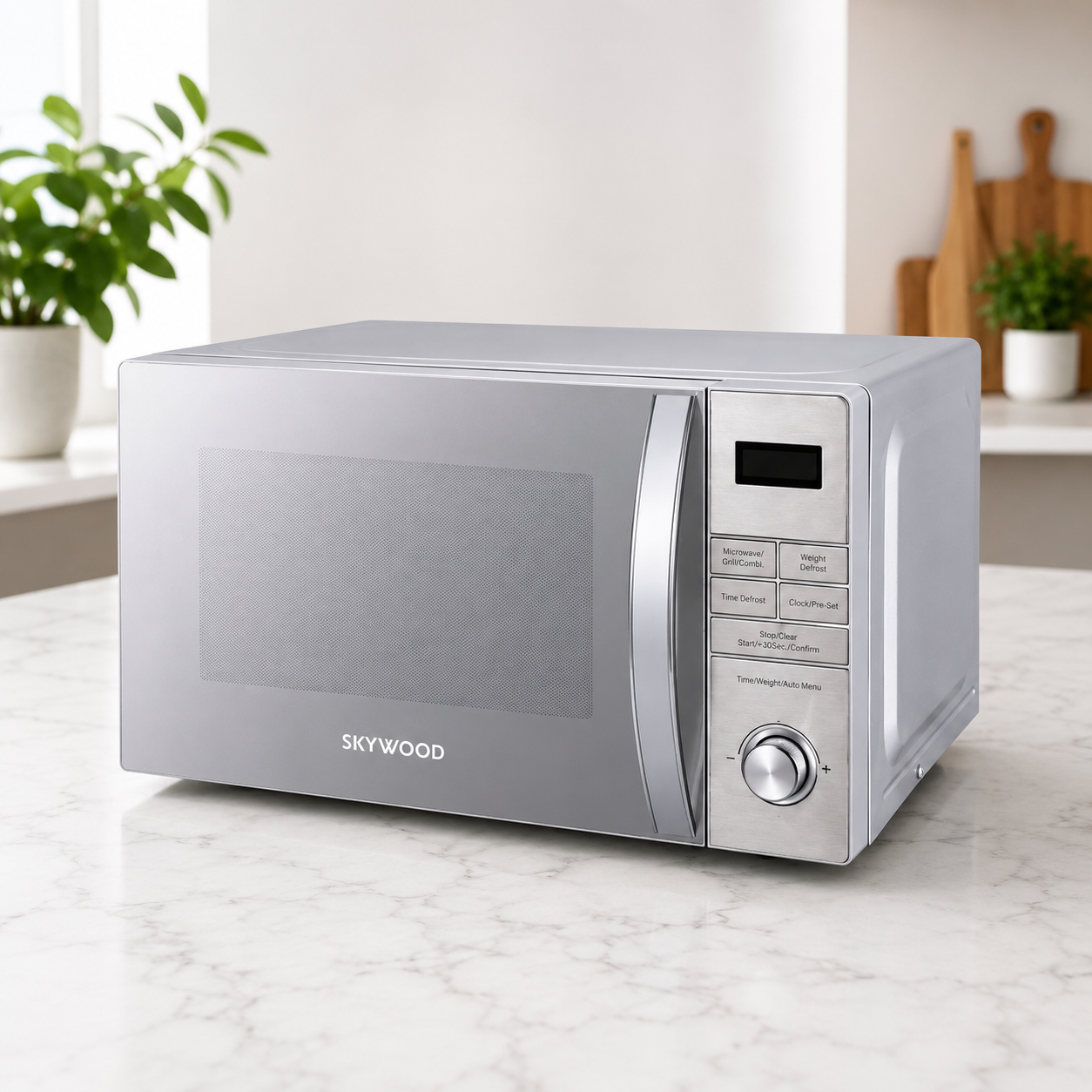 A silver Skywood microwave oven sits on a white marble kitchen countertop. The microwave features a brushed metal finish, a glass door with a silver handle, a digital display screen, and a control panel with buttons and a rotary dial.